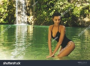stock-photo-sexy-woman-wearing-black-swimsuit-in-the-jungle-oasis-604186538.jpg