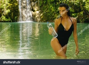 stock-photo-woman-with-a-bottle-of-mineral-water-in-the-jungle-oasis-648221137.jpg