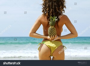 stock-photo-woman-with-a-pineapple-in-her-hands-on-the-beach-609587717.jpg