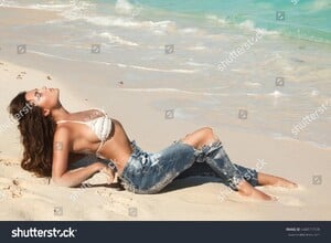 stock-photo-young-charming-woman-in-jeans-on-the-beach-444177139.jpg