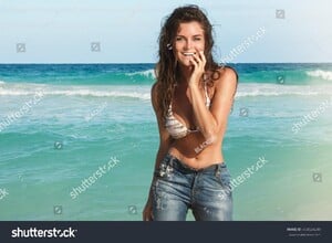 stock-photo-young-charming-woman-in-wet-jeans-on-the-beach-404524240.jpg