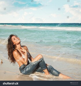 stock-photo-young-charming-woman-in-wet-jeans-on-the-beach-404524246.jpg