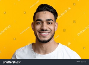stock-photo-closeup-portrait-of-cheerful-bearded-arab-guy-smiling-at-camera-over-yellow-studio-background-1996252148.jpg