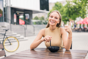young-beautiful-woman-with-thumbs-gesture-while-eat-salad-outdoors-cafe.jpg